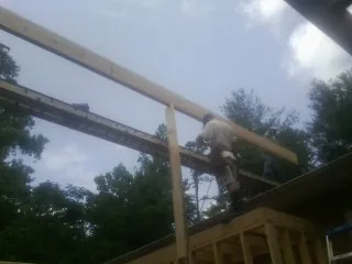 Carpenter setting a ridge beam over a new addition frame — Ice Dam Removal by Roofing Brothers in Wickliffe