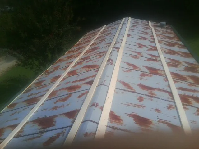 Rusted metal roof panels with new wood purlins before replacement — Storm Damage Roof Repair in Wickliffe by Roofing Brothers