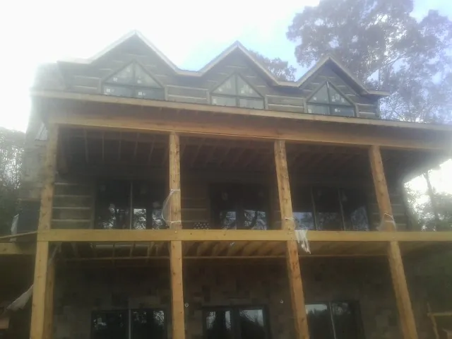 Dormers and porch framing on a large log home under construction — Roof Coating work by our crew in Wickliffe